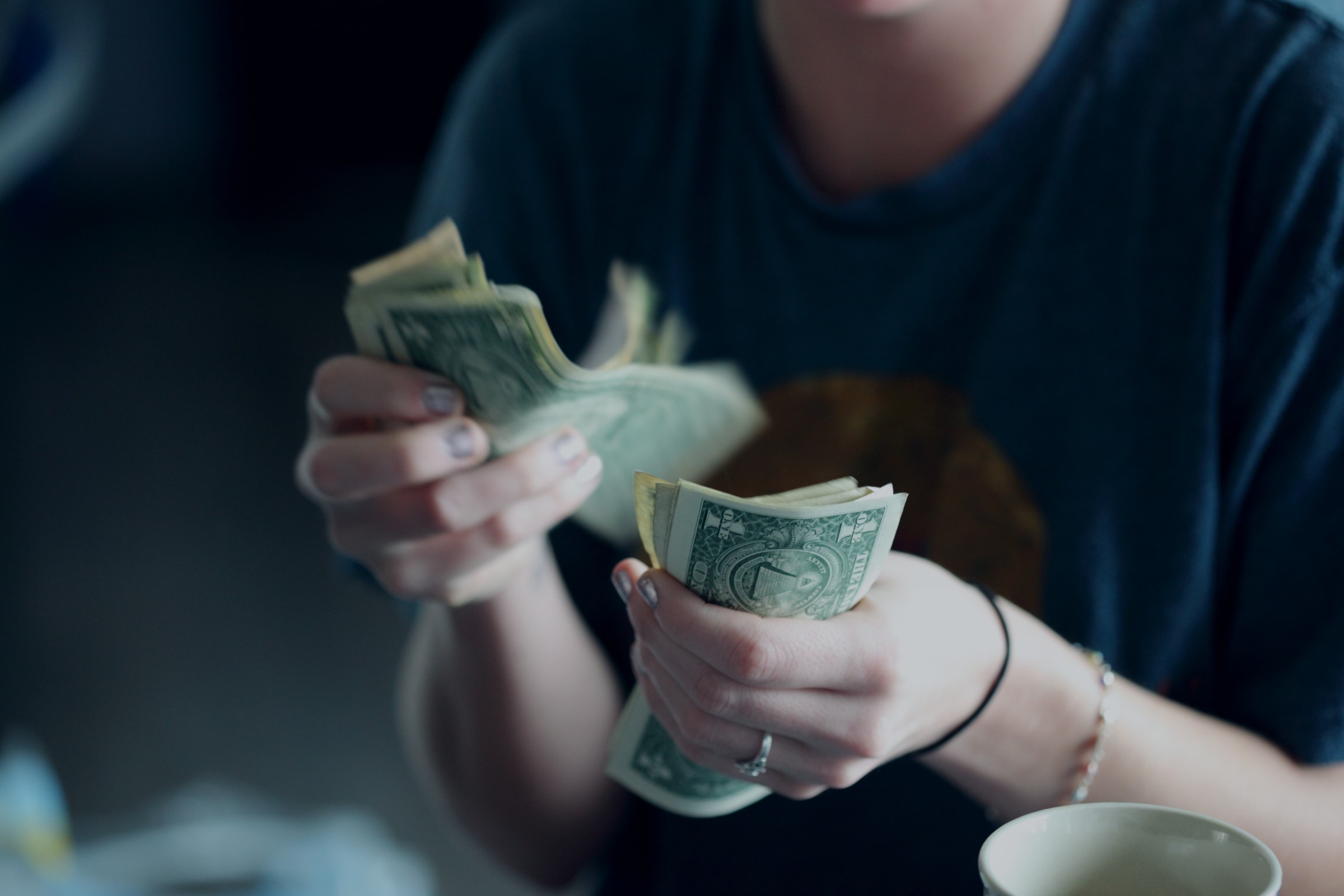 A woman counting dollar bills