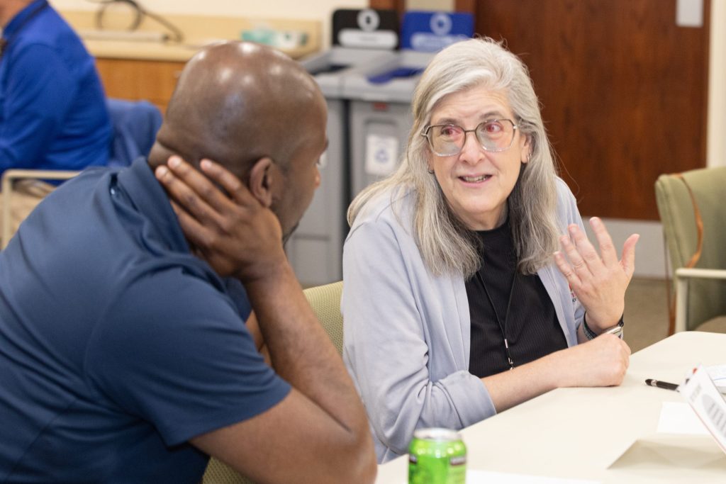 A woman and man are seated and in conversation. 